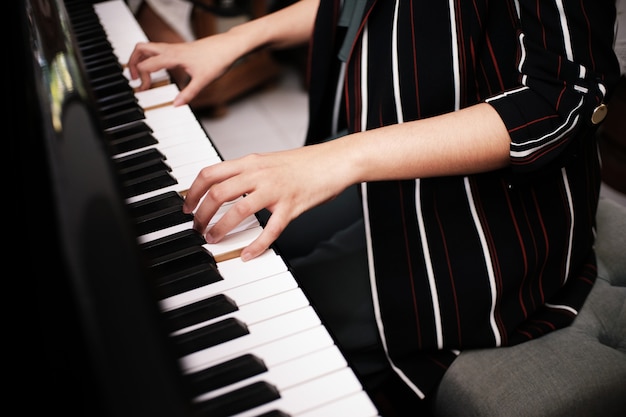 Mooie Aziatische meisje leren piano spelen.