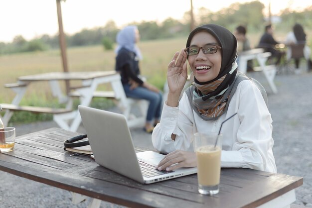 mooie aziatische moslimdame vrijetijdskleding die werkt met een laptop
