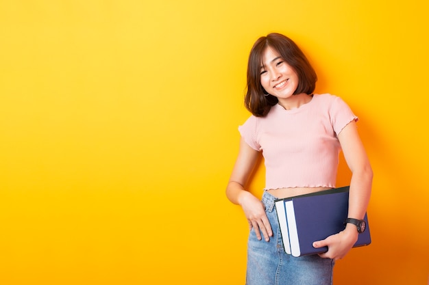 Mooie Aziatische student op gele muur