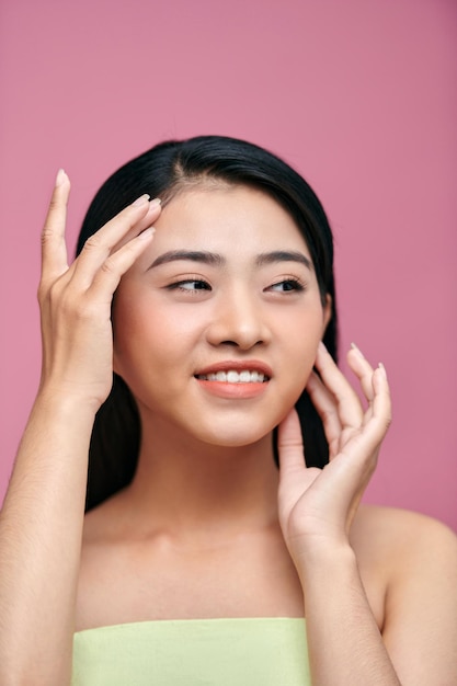 Mooie Aziatische vrouw aanraken wang en voorhoofd mooie natuurlijke schone huid natuur make-up