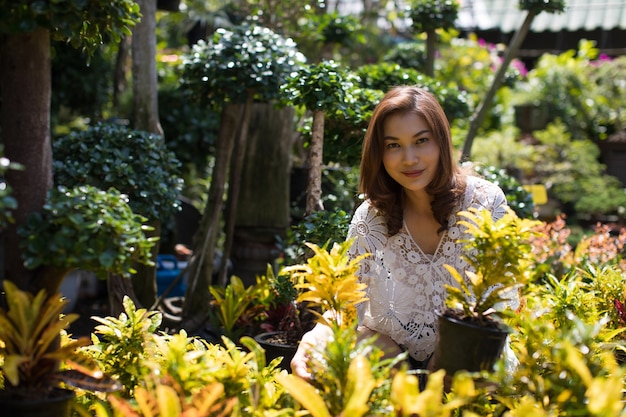 Mooie aziatische vrouw die bloem in bloemenwinkel selecteert, levensstijl van moderne huisvrouw.