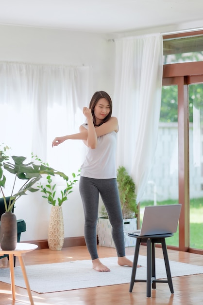 Mooie Aziatische vrouw die fit blijft door thuis te trainen voor een gezonde trendlevensstijl