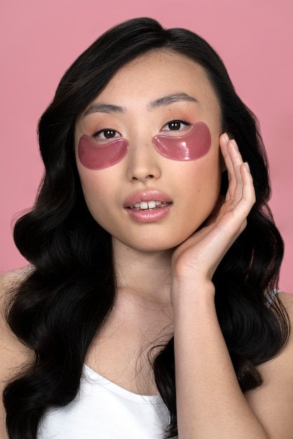 Foto mooie aziatische vrouw die huidbehandeling toepast