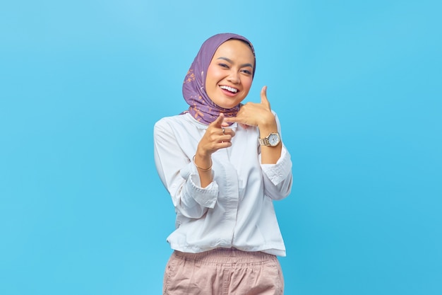 Mooie Aziatische vrouw die lacht en een oproep doet met de hand, wijzend met de wijsvinger op de camera