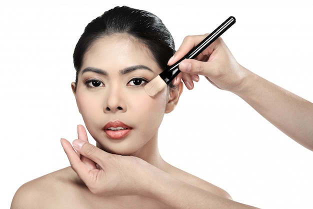 Mooie Aziatische vrouw die make-up doet