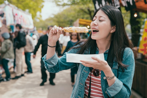 Mooie Aziatische vrouw die van Japanse snack geniet