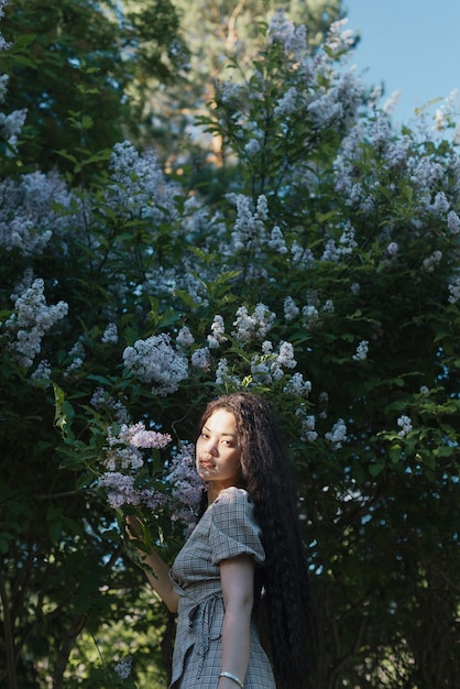 Mooie Aziatische vrouw die voor bloesembomen staat