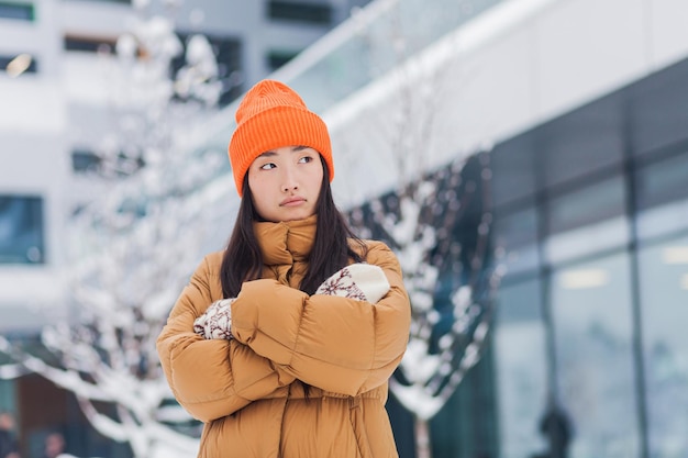 Mooie aziatische vrouw die wacht op een partner die aan het daten is na online daten op een koude winterdag met sneeuw
