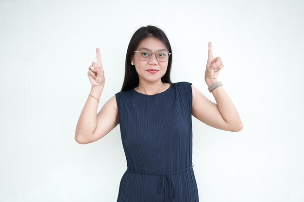 Mooie Aziatische vrouw in een formele jurk die het product toont en naar boven wijst geïsoleerd op een witte achtergrond