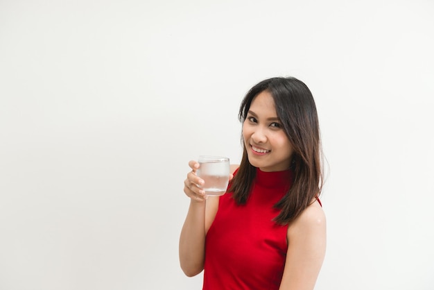 Mooie aziatische vrouw in rood met water in glas voor drank op witte achtergronddrank voor vers lichaam