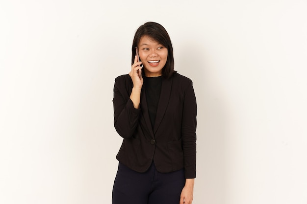 Mooie Aziatische vrouw in zwart pak praten op mobiele telefoon met blije gezichtsuitdrukking