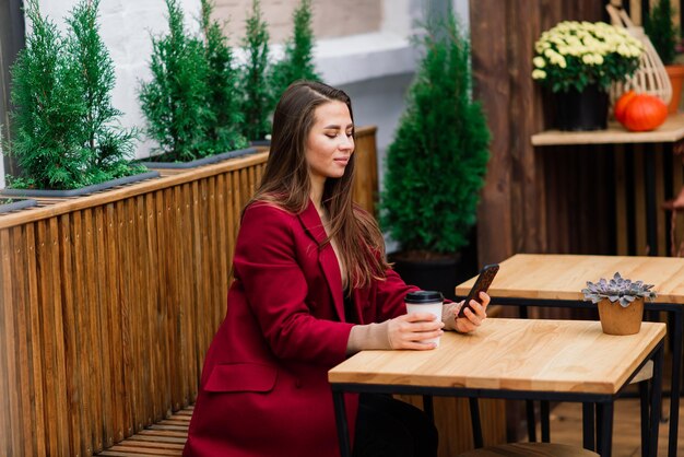 Mooie Aziatische vrouw koffie drinken in café, glimlachen, praten over de telefoon