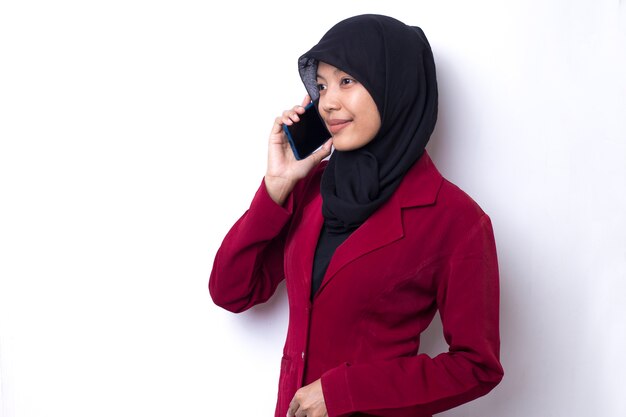 Mooie Aziatische vrouw met hijabportret die telefoon op witte ruimte met behulp van