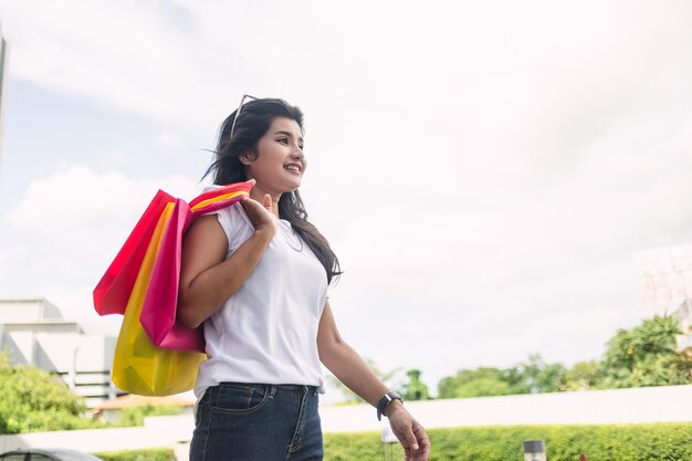 mooie aziatische vrouw met kleurrijke boodschappentassen in de stad