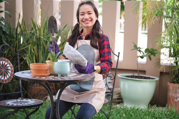 Mooie Aziatische vrouw plant in de boompot in de tuin