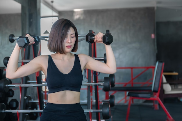 Mooie Aziatische vrouw speelt fitness in de sportschool