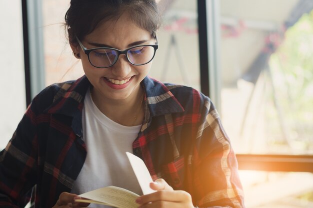 mooie Aziatische vrouw, student leesboek met plezier en gelukkig in vrije tijd.