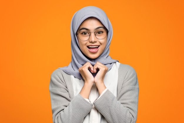 Mooie Aziatische vrouw vrolijk dragen lenzenvloeistof op oranje muur
