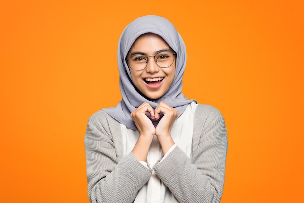 Mooie Aziatische vrouw vrolijk dragen lenzenvloeistof op oranje muur