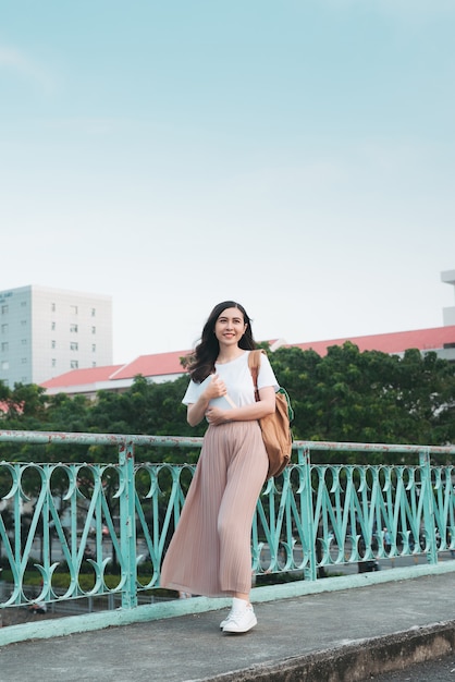 Mooie Aziatische vrouwelijke student die haar boeken buiten houdt, mensen onderwijs leerprogramma college concept