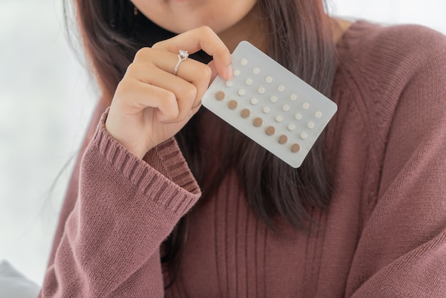 mooie Aziatische vrouwen die anticonceptiepil houden