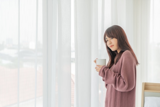 mooie Aziatische vrouwen die 's ochtends koffie drinken