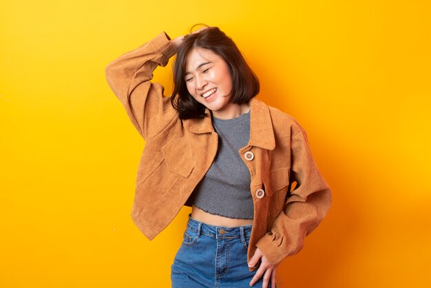 Mooie Aziatische vrouwen Universitaire student gelukkig op gele muur