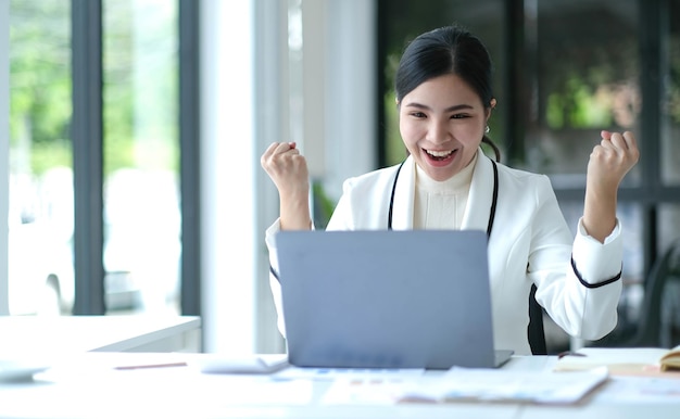 Mooie Aziatische zakenvrouw zittend op een laptop En het werk is gelukt en het doel is gelukkig en tevreden met haar bereikt