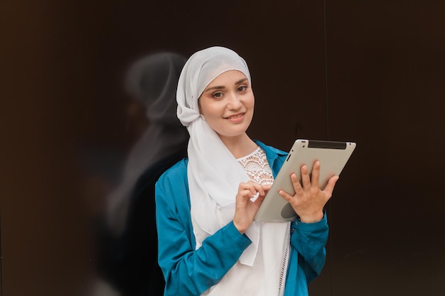 Mooie Aziatische zakenvrouwen die hijab dragen met haar tablet buiten.