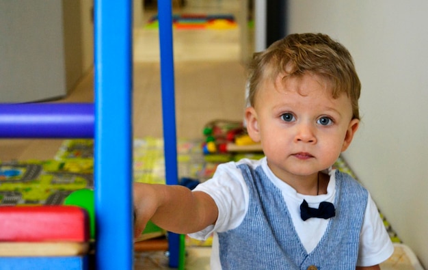 Mooie baby jongen met kind gezicht poseert fotograaf