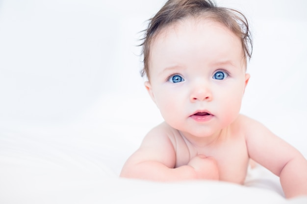 Mooie baby met blauwe ogen in bed