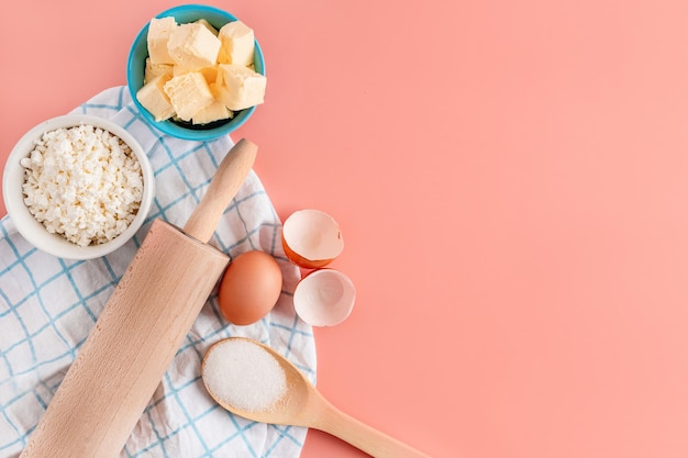 Mooie bakachtergrond Ingrediënten voor het bakken van eieren meel suiker boter op een roze achtergrond