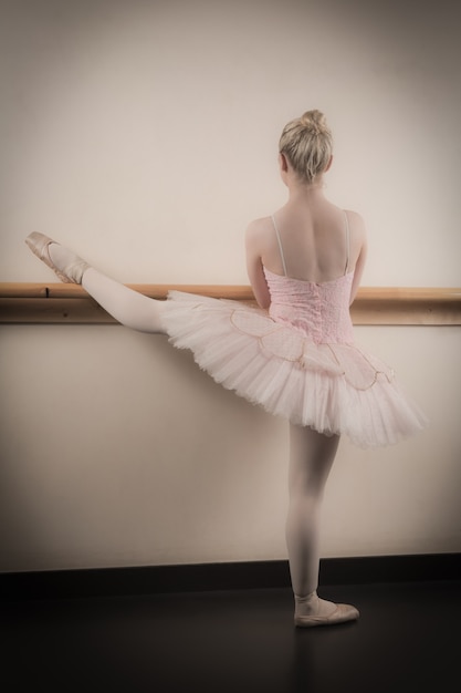 Foto mooie ballerina die met de staaf opwarmt