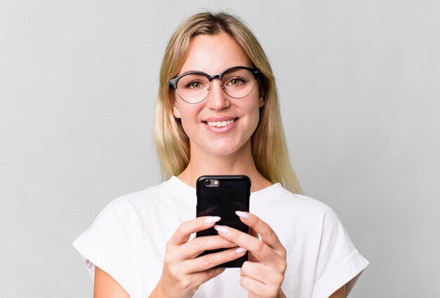 Mooie blanke blonde vrouw die haar smartphone gebruikt