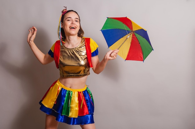 Foto mooie blanke braziliaanse vrouw die frevo carnaval-kleding draagt met frevo parasol dansen