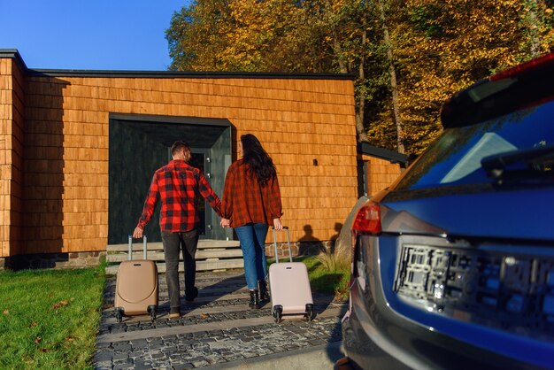 Mooie blanke familie die naar een nieuw huis verhuist, gaat met koffers naar een nieuw huis.