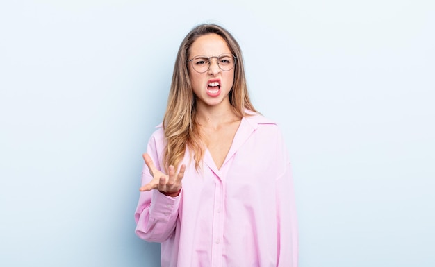 Mooie blanke vrouw die boos, geïrriteerd en gefrustreerd kijkt, schreeuwend wtf of wat is er mis met je?