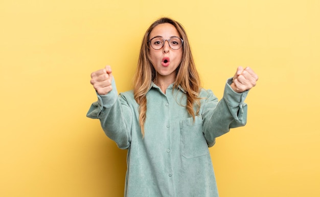 mooie blanke vrouw die een ongelooflijk succes viert als een winnaar, er opgewonden en blij uitziet en zegt: neem dat!