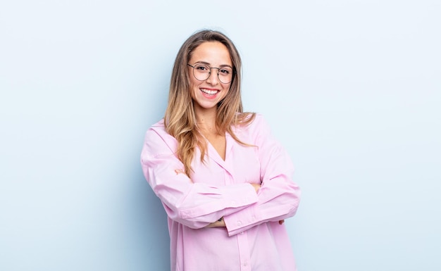 Mooie blanke vrouw die gelukkig lacht met gekruiste armen, met een ontspannen, positieve en tevreden pose