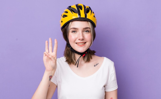 Mooie blanke vrouw die lacht en er vriendelijk uitziet met nummer drie fietsconcept