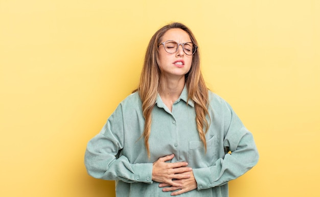 Mooie blanke vrouw die zich angstig, ziek, ziek en ongelukkig voelt, een pijnlijke buikpijn of griep heeft