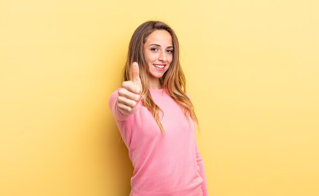 Mooie blanke vrouw die zich trots, zorgeloos, zelfverzekerd en gelukkig voelt, positief glimlachend met duimen omhoog