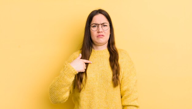 Mooie blanke vrouw die zich verward voelt, verward en onzeker, wijzend naar zichzelf, zich afvragend en vragend wie ik ben