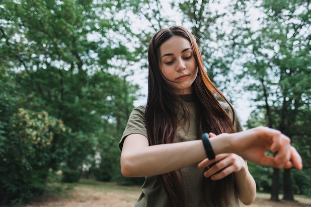 Mooie blanke vrouw gebruikt fitnesstracker tijdens sporttraining.