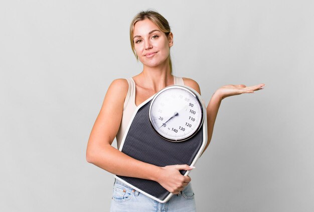 Mooie blanke vrouw met een gewichtsschaal dieet en fitness concept