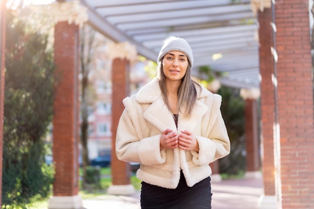 Mooie blanke vrouw met wollen muts in een winterlevensstijl in het stadspark