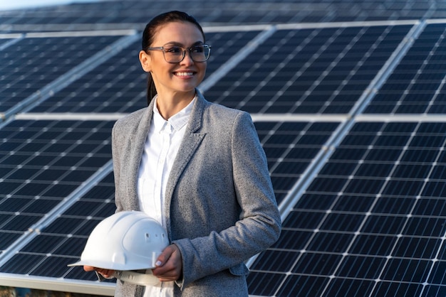 Mooie blanke vrouweningenieur op de boerderij voor zonne-energiebatterijen