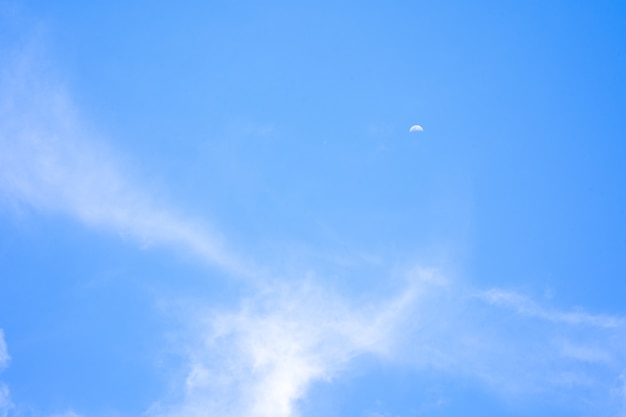 Mooie blauwe lucht met kleine witte wolk en halve maan als achtergrond