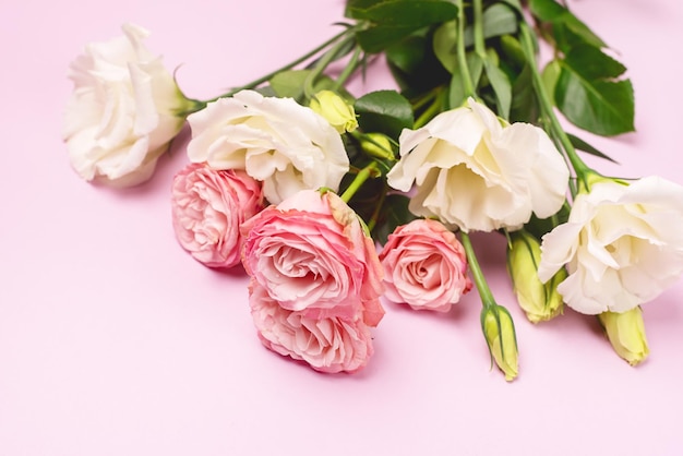 Mooie bloemen achtergrond Lente achtergrond Witte en roze bloemen op roze achtergrond Kopieer ruimte Horizontale roze rozen en Eustoma