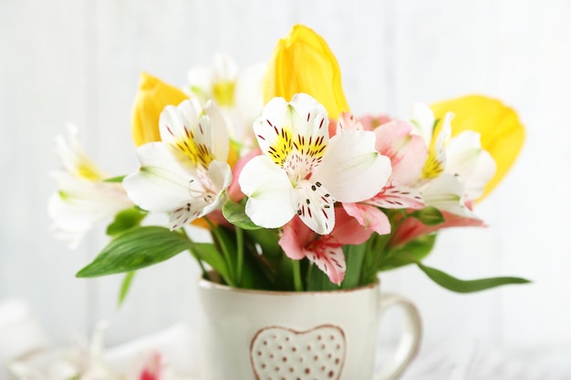 Mooie bloemen in kop op houten achtergrond